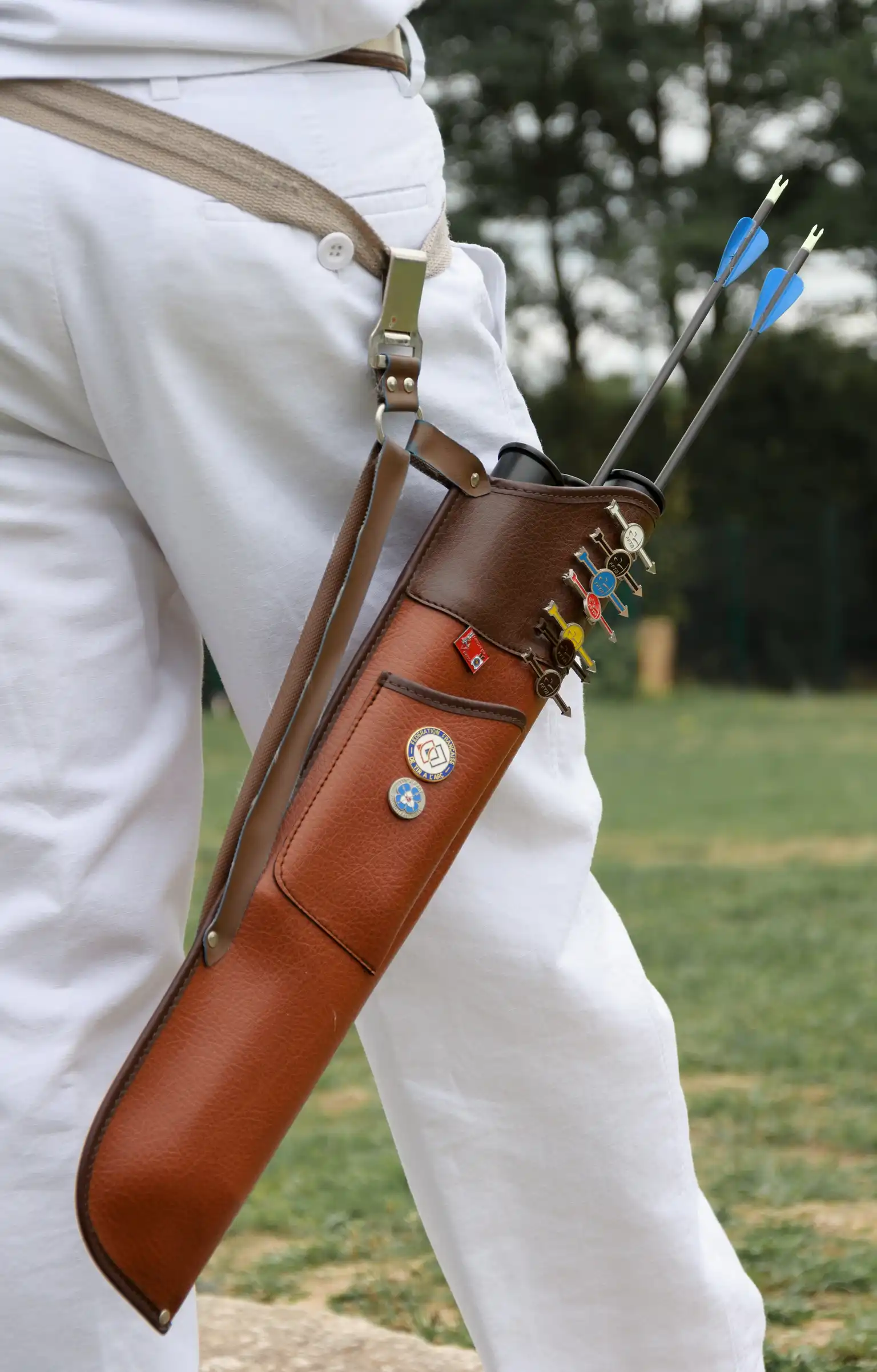 Close-up of a side quiver at the hip with an archer’s hand reaching for an arrow.