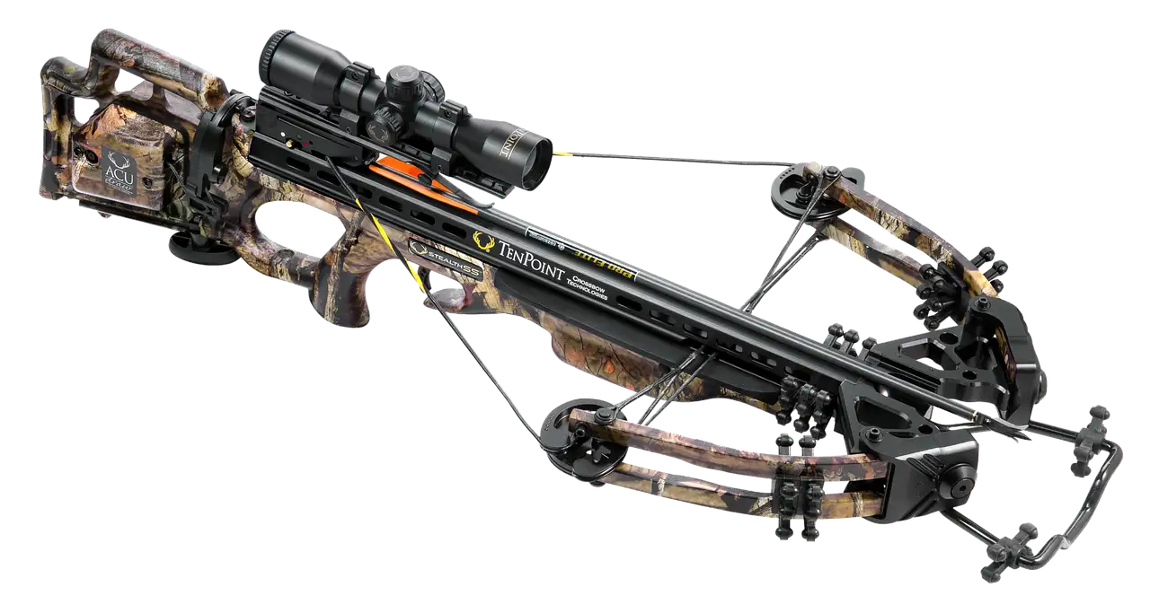Crossbow types laid out on a workbench beside bolts and a scope in natural light.