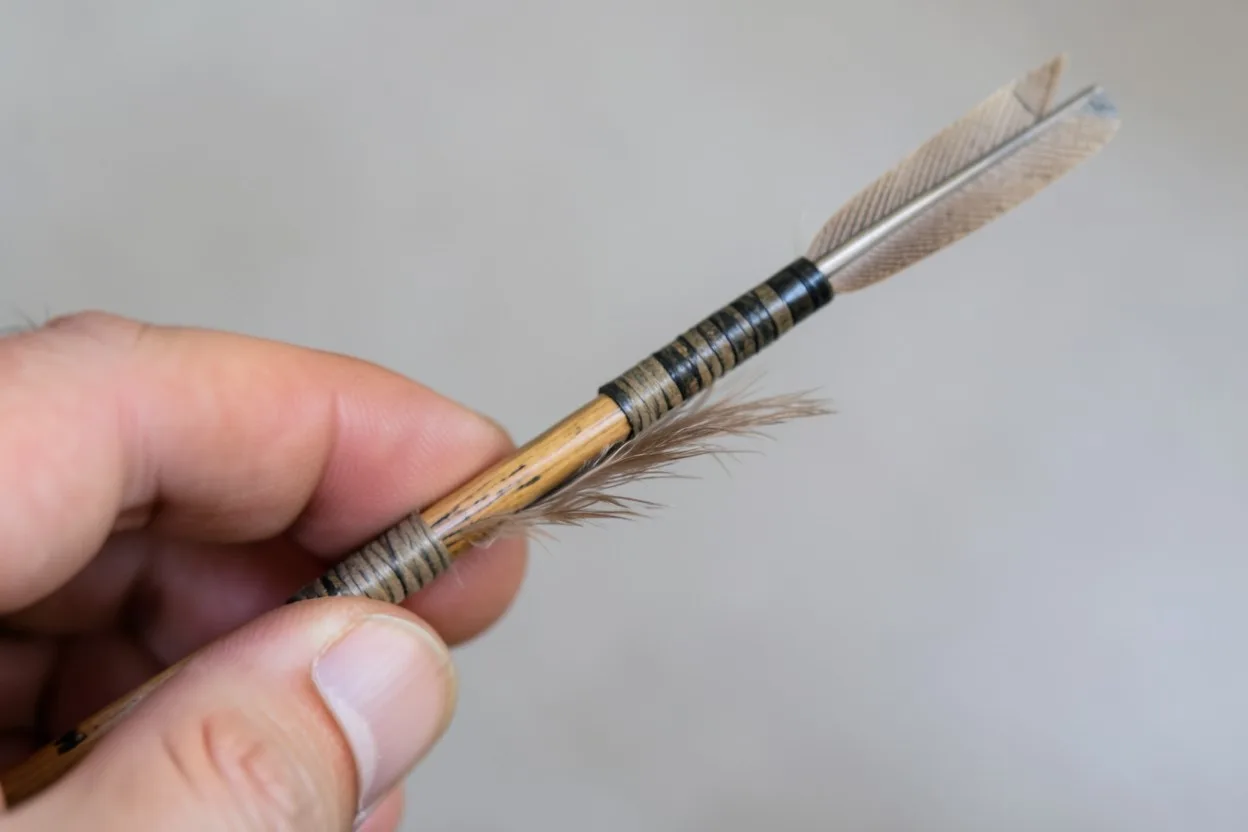 Close-up of a Native American arrow showing shaft, fletching, and stone point