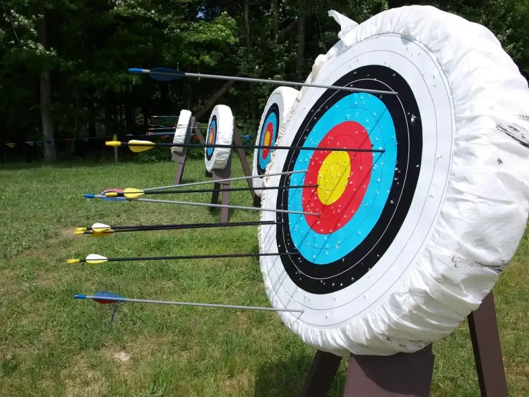 PVC and wood target stands set up in a backyard with foam targets for archery practice.