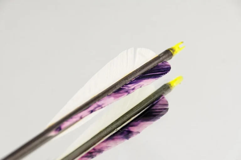 Bowhunter comparing arrows with different broadheads and inserts on a workbench