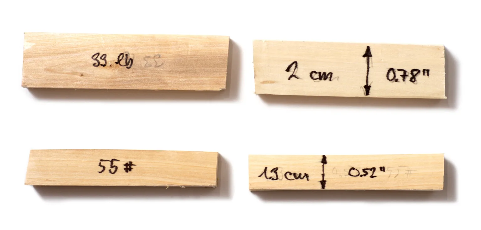 Hands testing an arrow shaft for spine on a bench with a spine tester and caliper