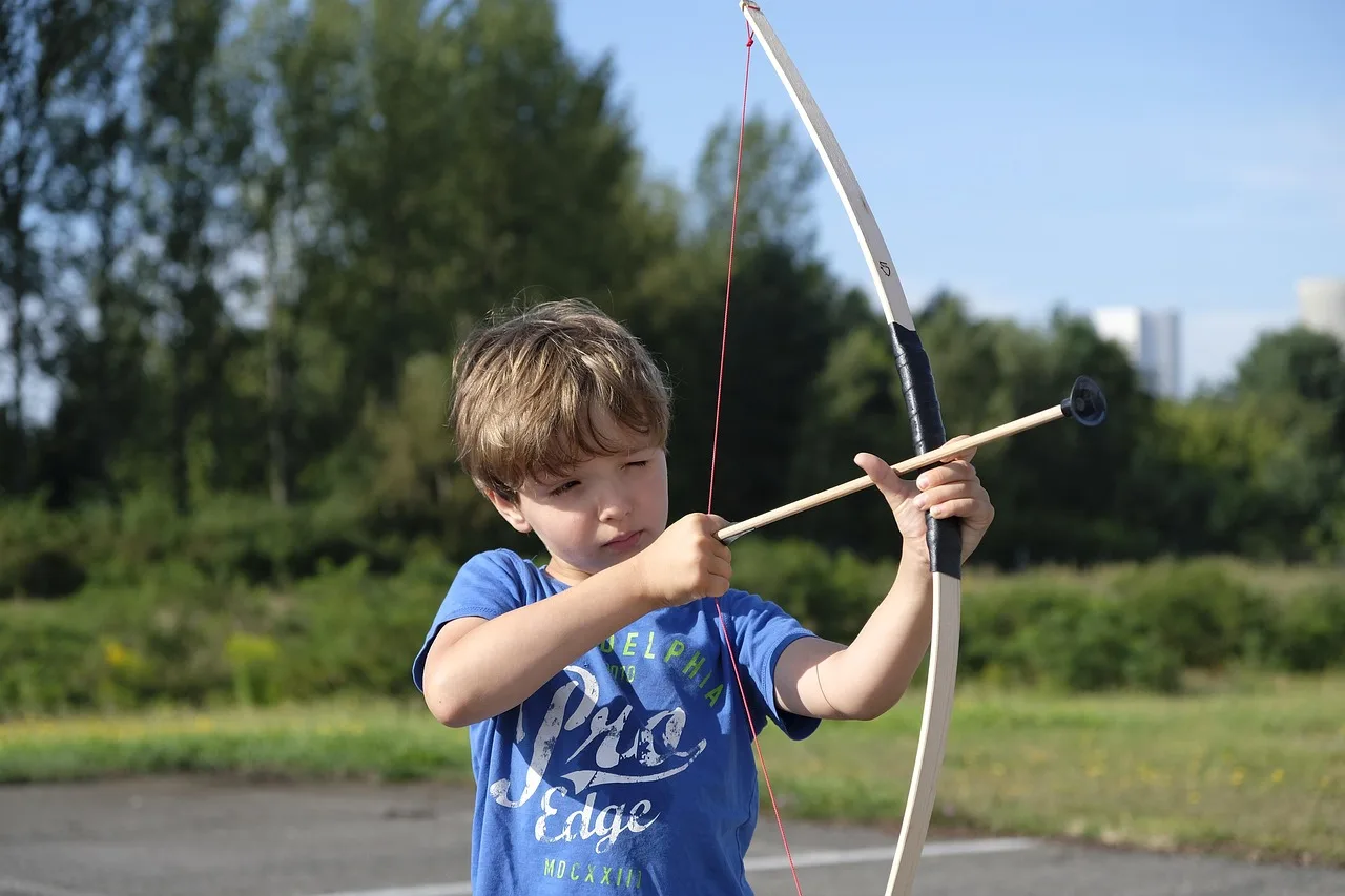 Archer tuning a compound bow at a 3D archery course in natural light