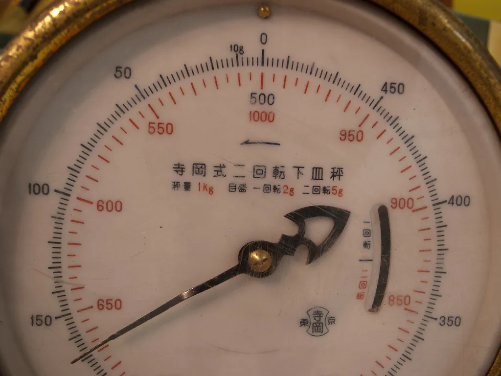 Hunter checking a compound bow on a digital bow weight scale in a workshop