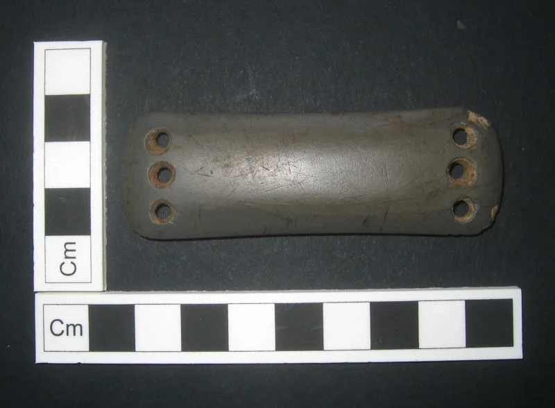 Close-up of an archer's forearm and bow hand at anchor with slim protection near the string