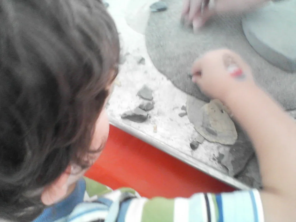Hands pressure-flaking a chert point with a bone awl and antler tine