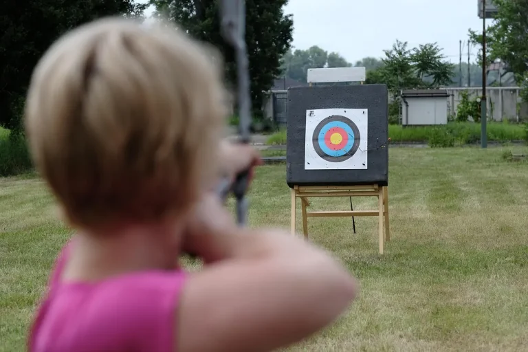 3D archery target on a braced wooden stand with ground stakes in a backyard