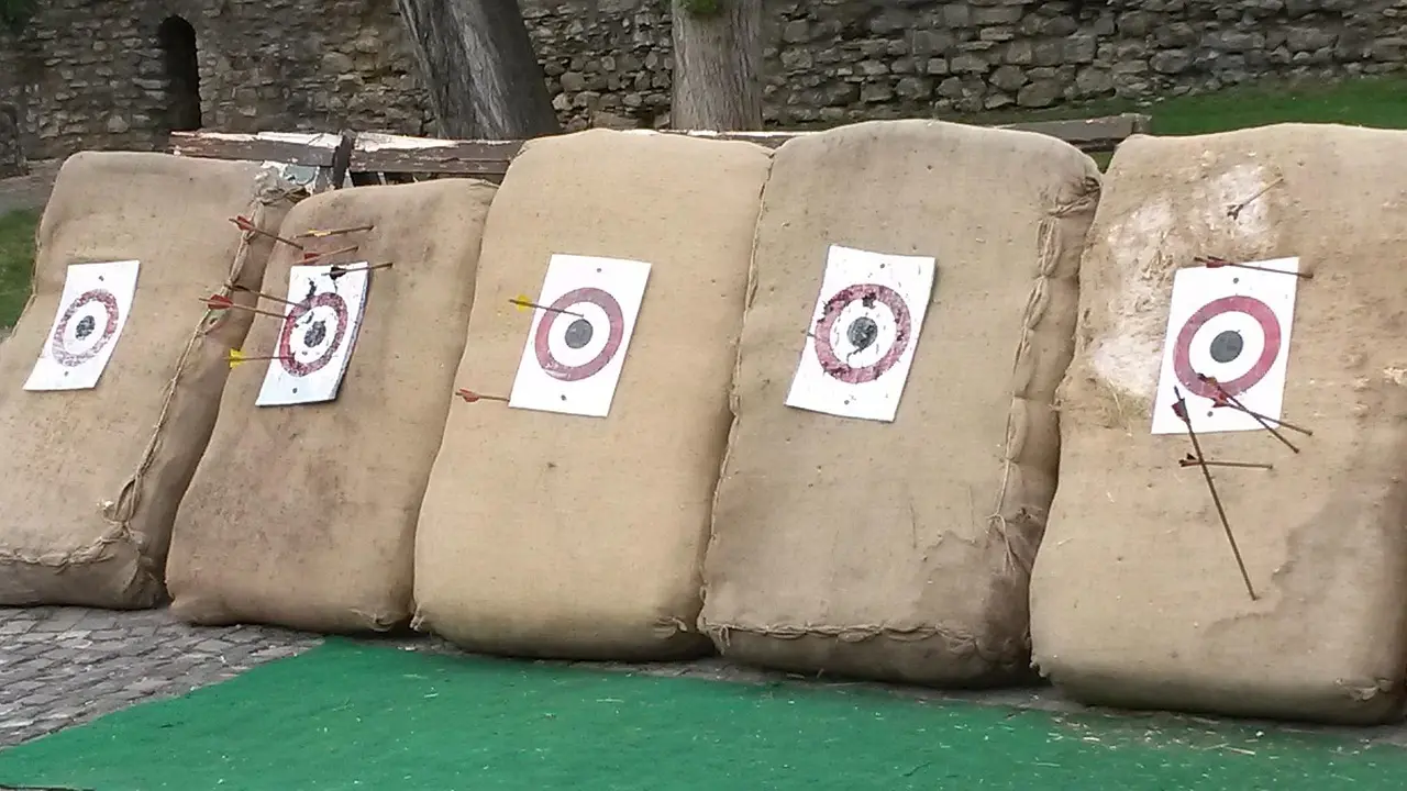 Local archery tournament with an archer at full draw on the shooting line.