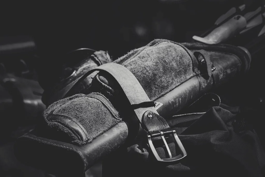 Close-up of a leather finger tab on a recurve bow string during the draw