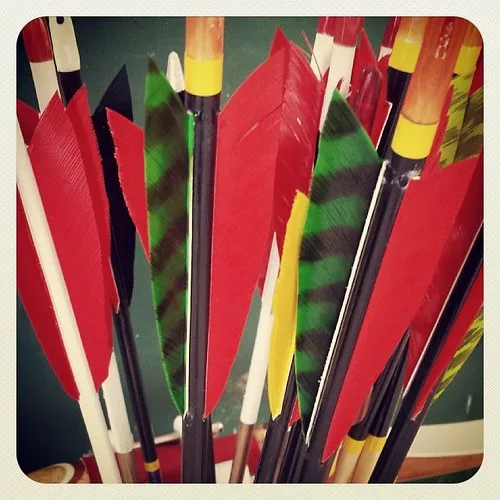 Close-up of wood and carbon arrows being checked for spine and nock fit on a recurve setup